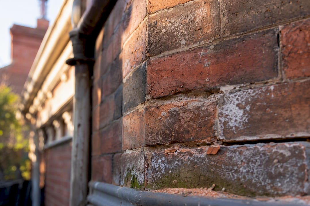 Moisture damaged heritage brick wall close-up