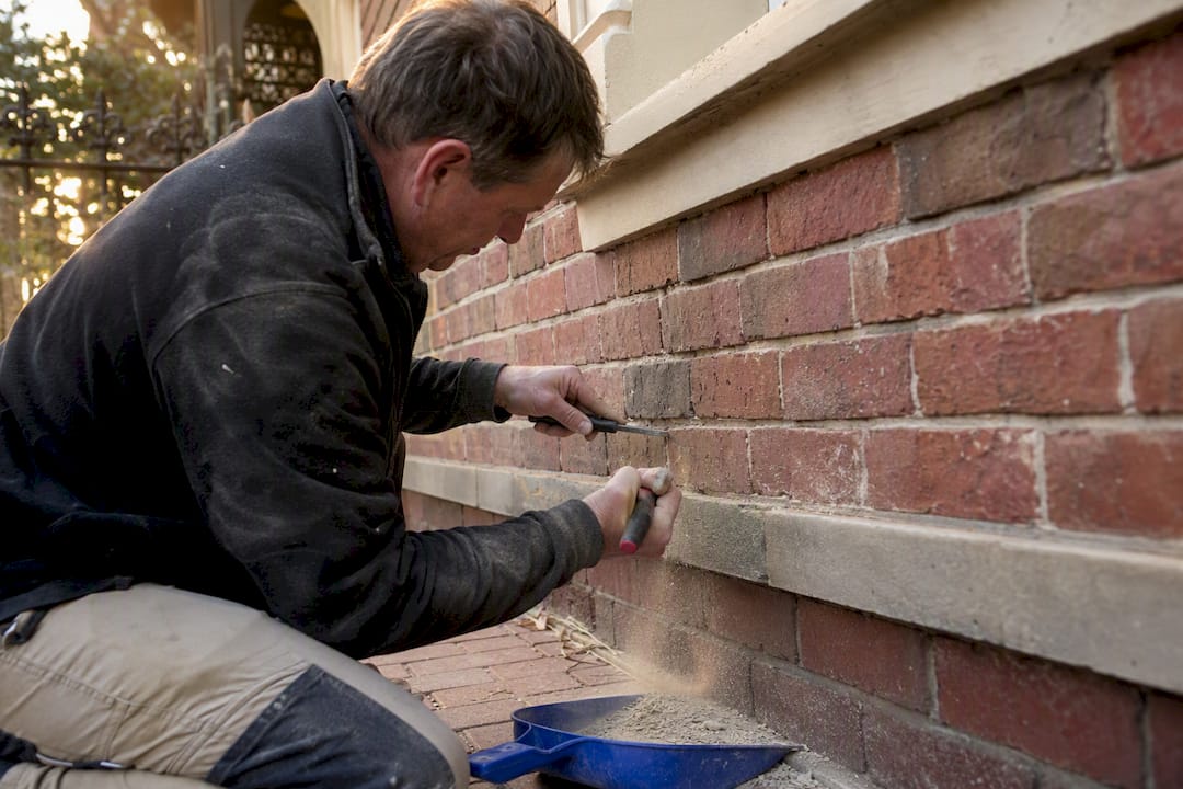 Raking out mortar from heritage brick wall