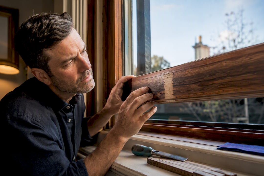 Specialist assessing restored timber sash window