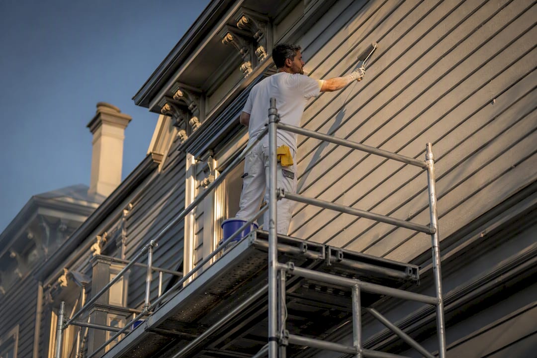 Painter using scaffolding on heritage house