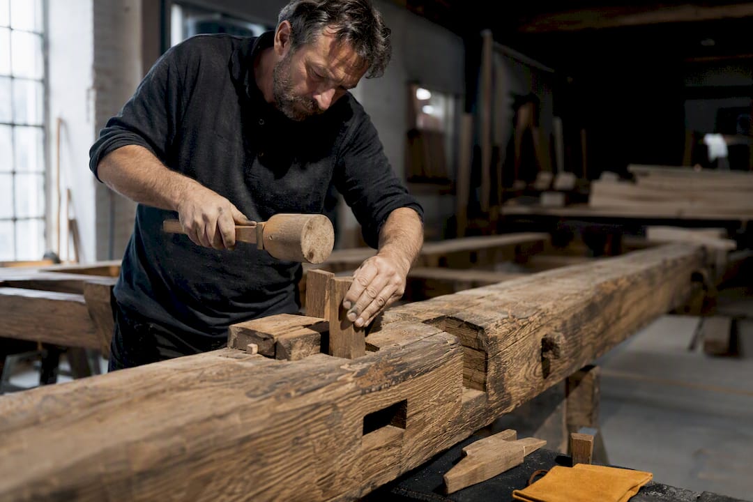 Carpenter dismantling historic timber frame