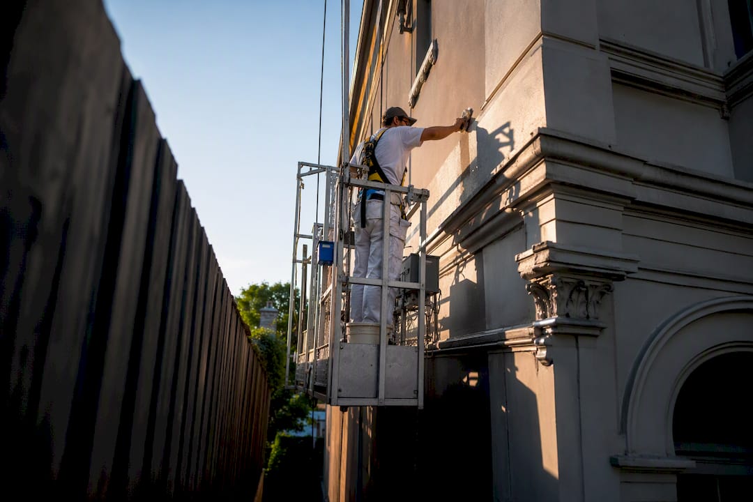 Painter accessing narrow Victorian terrace facade