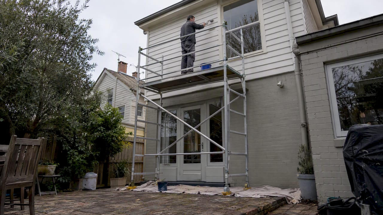 Painter using scaffold on a multistorey home