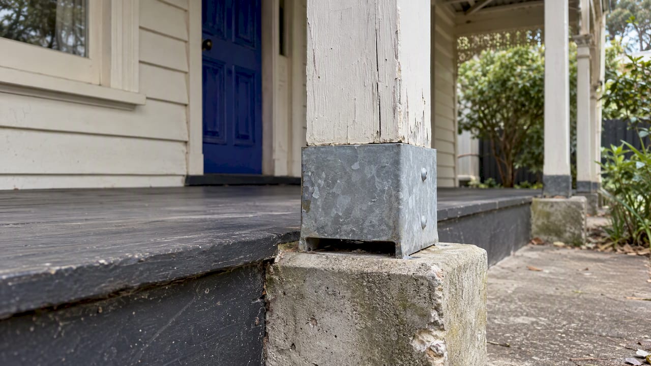 Timber post isolated from concrete by stirrup